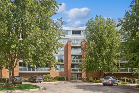 Front view of a multi-story building with large windows and brick facade.