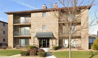 Front view of a three-story apartment building with balconies.