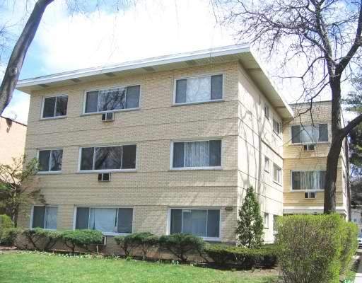 Front view of a multi-story apartment building with brick exterior.