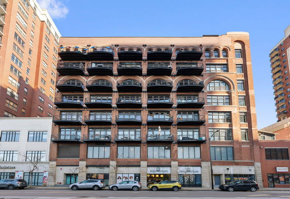 Front view of a multi-story brick building with balconies.