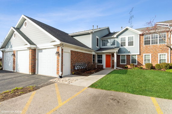 Front view of a two-story house with a brick and siding facade and a double garage.