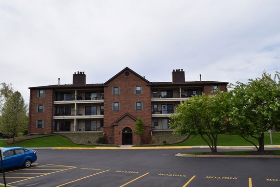Front view of a multi-story brick apartment building.