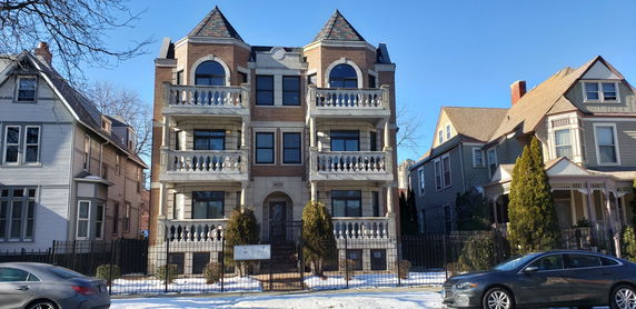Front view of a multi-story building with balconies and a decorative facade.