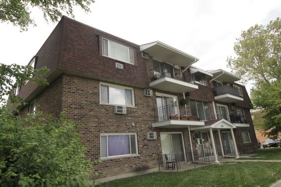 Front view of a multi-story apartment building with balconies.
