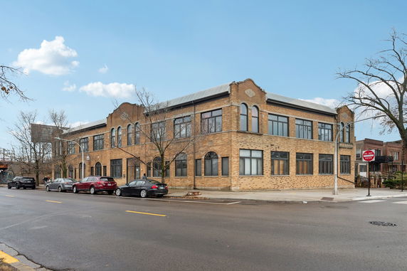 Front view of a two-story brick building on a street corner.