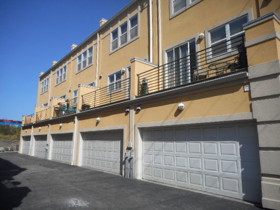 Front view of a multi-story building with garage doors.