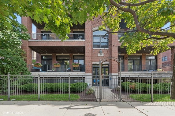 Front view of a multi-story brick residential building with balconies.
