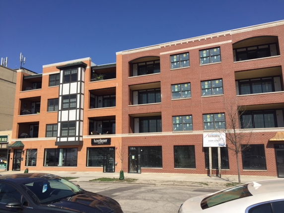 Front view of a multi-story brick building with balconies.