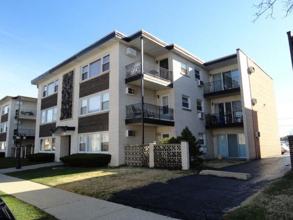 Front view of a three-story apartment building with balconies.