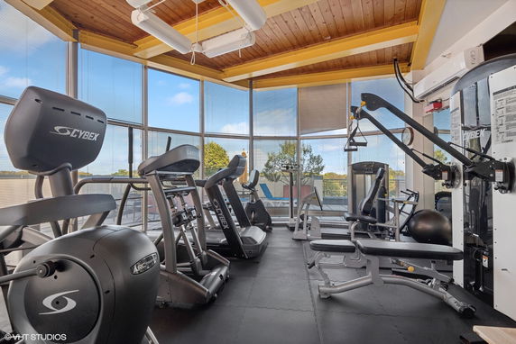 Gym area with exercise equipment and large windows.