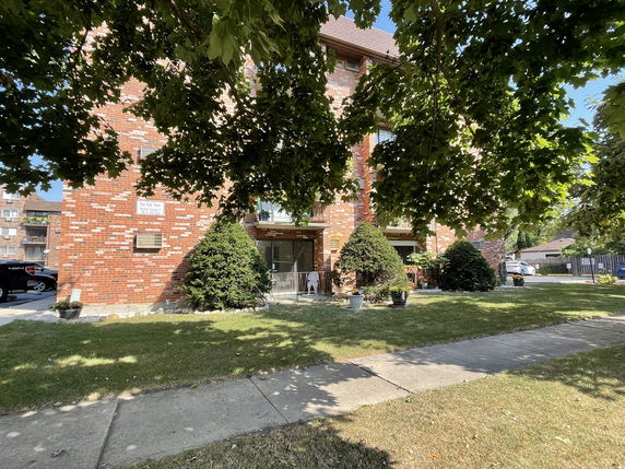 Front view of a brick multi-story residential building.