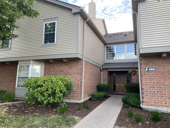Front view of a two-story house with brick and siding exterior and a central entrance.