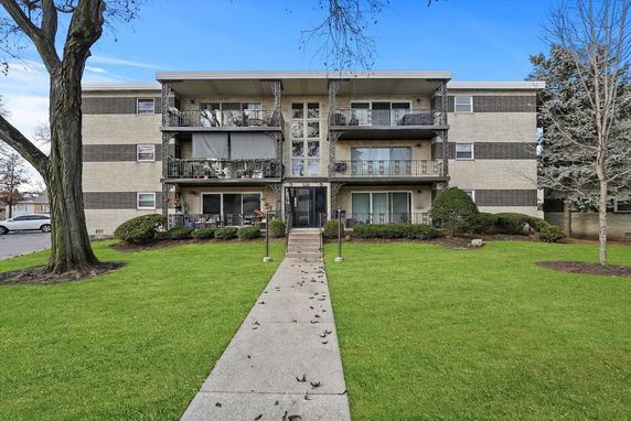Front view of a three-story residential building with balconies.