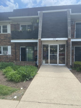 Front view of a two-story brick building with a balcony and entrance.