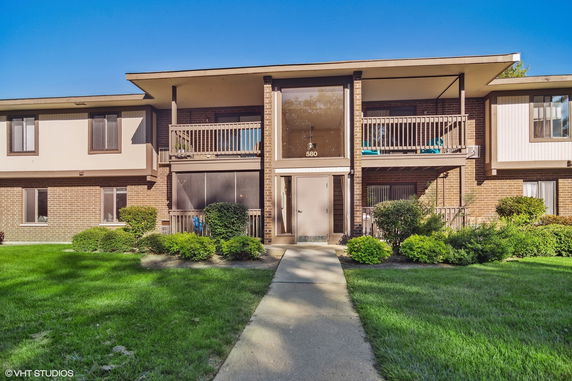 Front view of a multi-story apartment building with balconies.