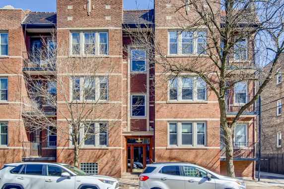 Front view of a multi-story brick apartment building.