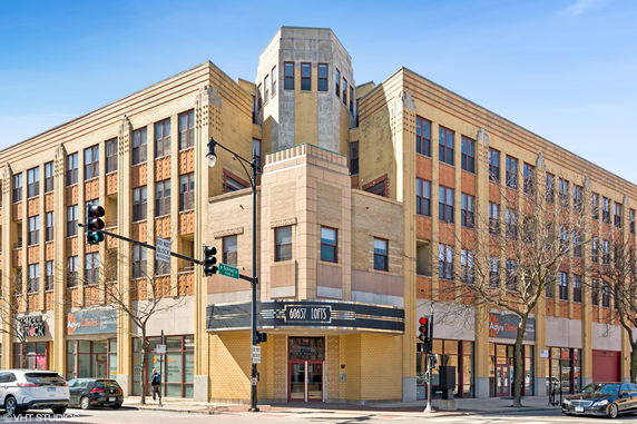 Front view of a multi-story building with commercial spaces on the ground floor.