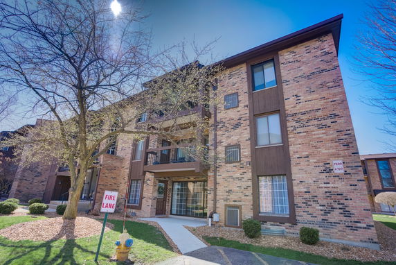 Front view of a multi-story brick apartment building.