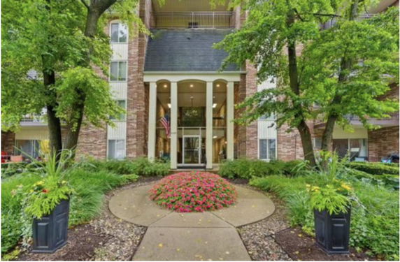 Front view of a multi-story building with columns and an entrance area.