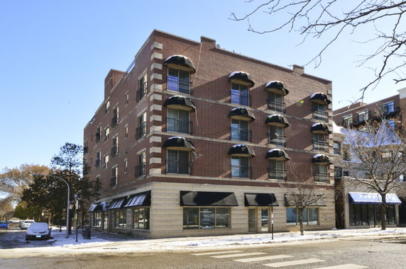 Front view of a multi-story brick building with awnings.