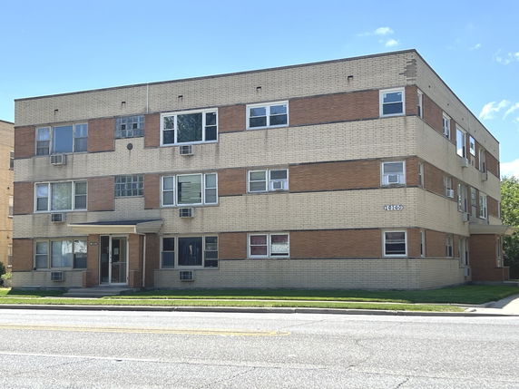 Front view of a three-story brick apartment building.