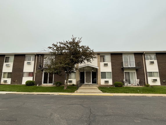 Front view of a two-story apartment building with balconies.