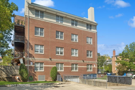 Front view of a brick apartment building with multiple windows and balconies.