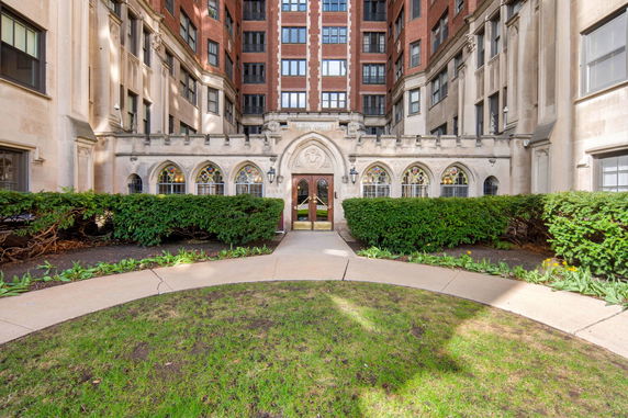 Front view of a multi-story brick building with ornate archways and stained glass windows.