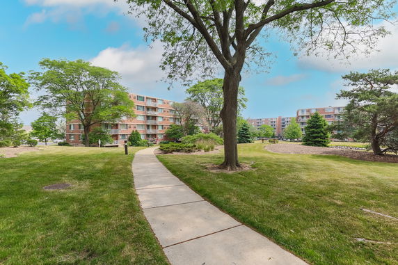 View of apartment buildings with a landscaped area and trees