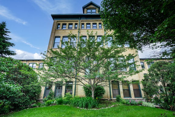 Front view of a multi-story building with numerous windows and a peaked roof section.
