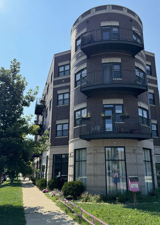 Front view of a multi-story brick building with rounded balconies.