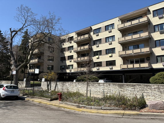 Front view of a multi-story apartment building with balconies.