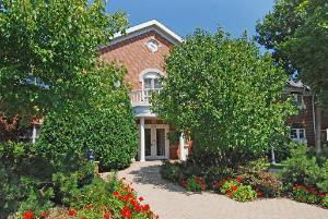 Front view of a multi-story house with a prominent entryway and landscaping.