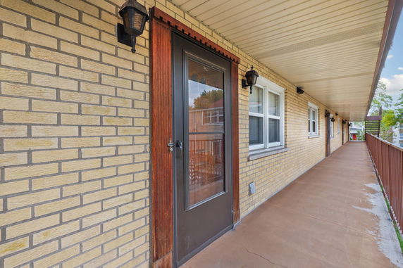 Exterior view of a building with a brick facade and covered corridor.