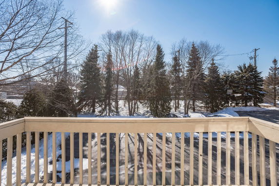 View from a building showing trees and a snowy landscape.