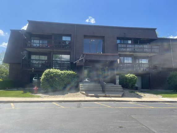 Front view of a multi-story apartment building with balconies.