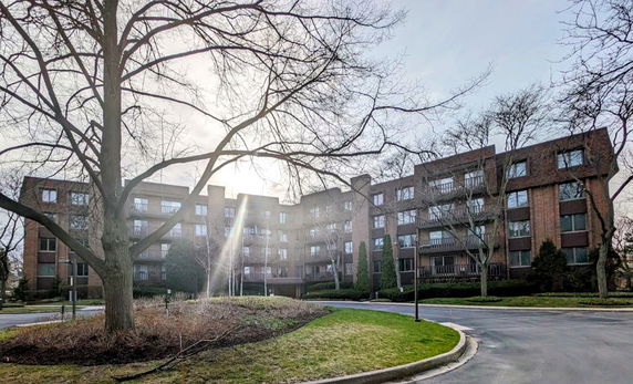 Front view of a multi-story brick building with numerous windows and balconies.