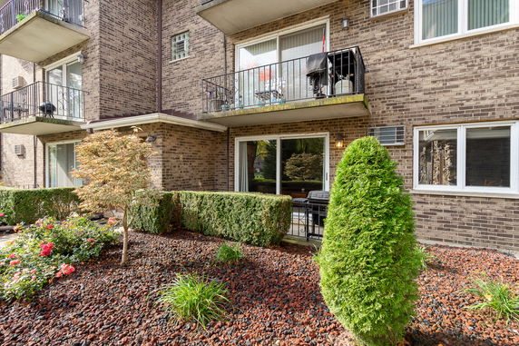 Front view of a brick apartment building with balconies.