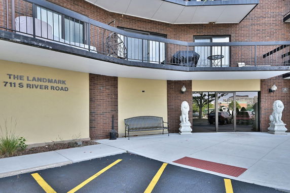 Front view of a multi-story building with a balcony and entrance area.