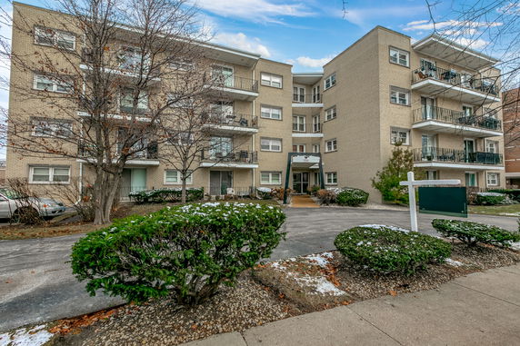 Front view of a multi-story apartment building with balconies.