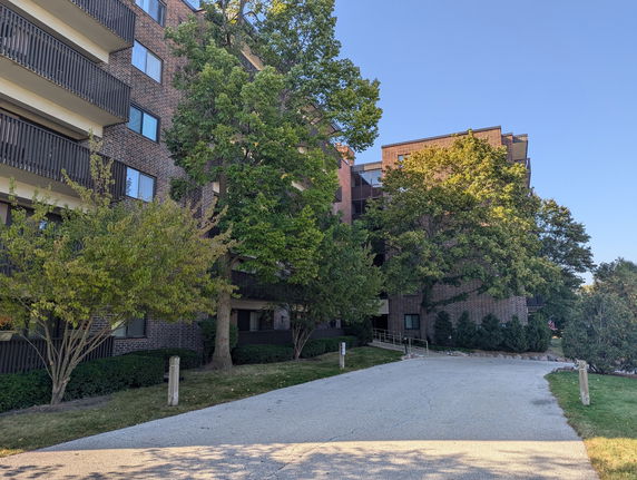 Front view of a multi-story brick apartment building with balconies.