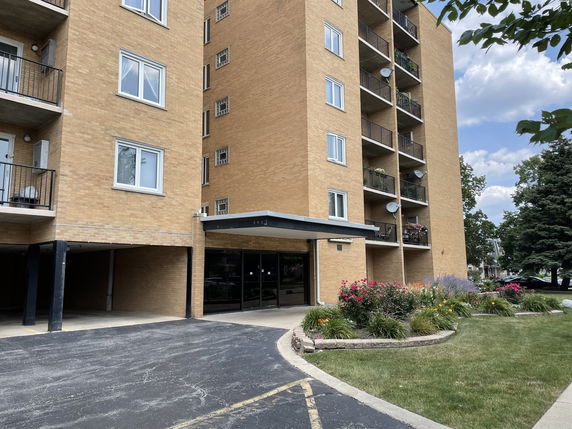 Front view of a multi-story apartment building with balconies.