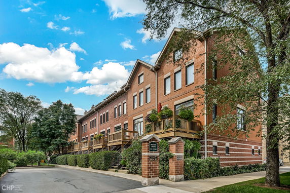 Front view of a multi-story brick townhouse row with balconies.