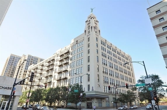 Front view of a multi-story building with a distinctive tower and decorative elements.