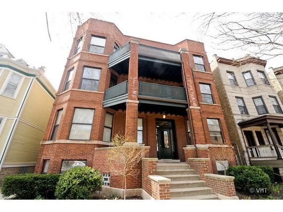 Front view of a multi-story brick building with balconies.