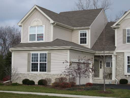Front view of a two-story house with a gable roof and stone accents.