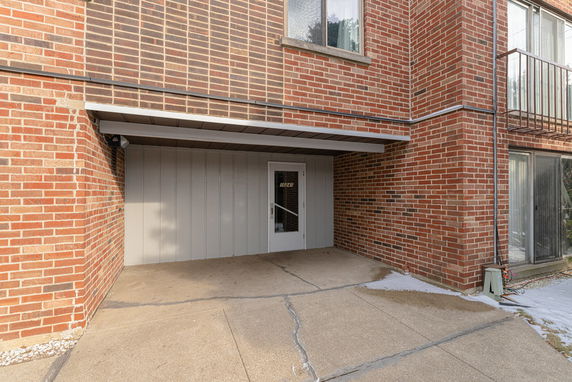 Front view of a brick multi-story building with a covered entrance.