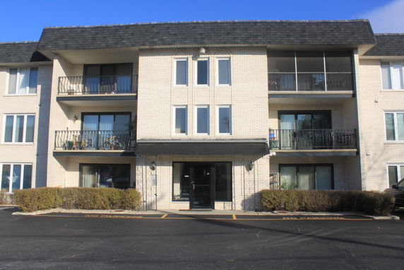 Front view of a three-story apartment building with balconies.