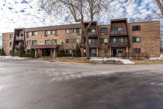 Front view of a three-story brick building with balconies.