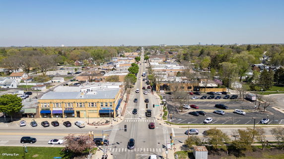 Panoramic view of a town with roads, buildings, and greenery.